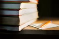 Close-up of a stack of books and a pen with paper for notes. The concept of home reading of paper books, education and school Inst