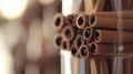 Close up of a stack of cinnamon sticks in a glass container with a blurred background showing spices Royalty Free Stock Photo