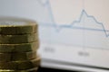 Close up of a Stack of Coins With Graph in the Background