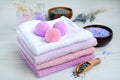Close-up of a stack of colored towels with aroma balls and salt with lavender on a light wooden background. Concept of beauty Royalty Free Stock Photo