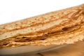 Close up on a stack of crepes french pancakes on a plate, white background