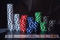 Close up stack of different colored poker chips and playing cards on the casino table isolated over black background. Gambling Royalty Free Stock Photo