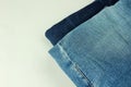 Close up of stack of jeans or denim pants isolated on white background. Royalty Free Stock Photo