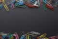 Close up of stack of multi coloured paper clips and copy space on black background