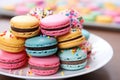 close-up of a stack of multicolored macarons on a white plate