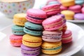close-up of a stack of multicolored macarons on a white plate