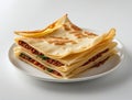 Stacked Mutabbaq savory flatbread filled with meat and herbs on a white plate against a white Royalty Free Stock Photo