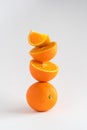 Close-up of a stack of oranges, whole and sliced, a tower of oranges on white background with copy space Royalty Free Stock Photo