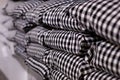 Close-up of a stack of pillows in a black and white cage. Stack of pillows on a shelf. The store sells modern gray plaid pillows. Royalty Free Stock Photo