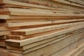 A close-up of a stack of pine boards, appearance lumber, wood panel boards and planks neatly piled up together