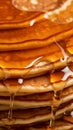 Close up stack of rich pancakes, honey or maple syrup cascades down, creating a enticing sight Royalty Free Stock Photo