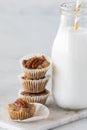 A close up of a stack of salted caramel pecan tarts with a bottle of milk.