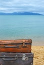 Old vintage travel suitcases over sea beach Royalty Free Stock Photo