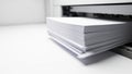 Closeup of a stack of white paper being fed into a printer highlighting office work and document preparation Royalty Free Stock Photo