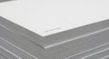 Close up of a stack of white paper with subtle gray lines on a textured surface Royalty Free Stock Photo