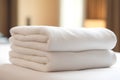 close up of a stack of white towels in a hotel room.