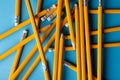 Close up of stack of yellow pencils with erasers on blue background