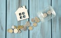 Close-up of stacked coins and house figurines