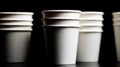 Close-up of stacked, white disposable cups against a stark black background Royalty Free Stock Photo
