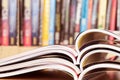 close up stacking of opened magazine with blurry bookshelf background , extremely shallow DOF Royalty Free Stock Photo