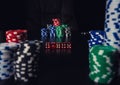 Close up stacks of different colored poker chips and playing dices on the casino table. Gambling tournament betting for success Royalty Free Stock Photo