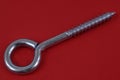 Galvanized steel screw eyelet close-up on red background