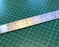 Close up of stainless steel metal ruler on a cutting mat