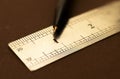 Close up of a stainless steel scale r ruler showing a one inch point with pen, Selective focus, isolated on Dark Royalty Free Stock Photo
