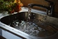 Close up of stainless steel sink, plug hole filled with water and food debris