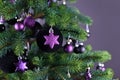 Close up of star shaped purple glass tree ornament bauble with decorated Christmas tree with other seasonal tree ornaments Royalty Free Stock Photo