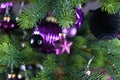 Close up of star shaped purple glass tree ornament bauble with decorated Christmas tree with other seasonal tree ornaments Royalty Free Stock Photo