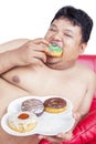 Close up of starving fat man eat donuts on studio