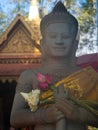 Close Up of a Statue of Buddha Holding Lotus Blossoms in Siam Reap