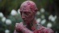 Close-up of a statue of a person without head and arms, adorned with a variety of colorful flowers Royalty Free Stock Photo