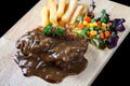 Close up steak pork with mushroom sauce, french fries and salad Royalty Free Stock Photo