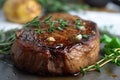 close-up of steak and sprigs of fresh thyme, with potatoes in the background