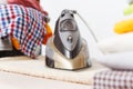 Close up steam iron colorful clothes washed laundry on white background. Housekeeping. Copy space advertisement. Place for text. Royalty Free Stock Photo