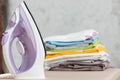 Close up steam iron colorful clothes washed laundry on white background. Housekeeping. Copy space advertisement. Place for text. Royalty Free Stock Photo