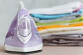 Close up steam iron colorful clothes washed laundry on white background. Housekeeping. Copy space advertisement. Place for text. Royalty Free Stock Photo