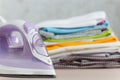 Close up steam iron colorful clothes washed laundry on white background. Housekeeping. Copy space advertisement. Place for text. Royalty Free Stock Photo