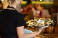 Close-up of steamed clams. Waiter holds a plate with clams in a restaurant. Sea food cuisine Royalty Free Stock Photo