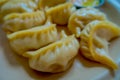 Close up of steamed Momo served in a white plate. A popular Nepalese food that is also common in Chiana, Bhutan, Tibet