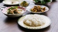 Close-up steamed rice in a plate served with Thai blur foods in the background