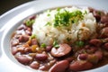 Close-up of steaming hot red beans and rice with smoked ham hock and a sprinkle of Cajun seasoning