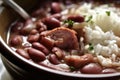 Close-up of steaming hot red beans and rice with smoked ham hock and a sprinkle of Cajun seasoning