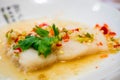 Close up steaming white dolly fish with sour and spicy sauce and herb.