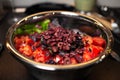 Close-up of steel bowl with prepared ingredients for salad.