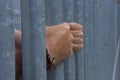 Close up of steel cage of jail and hand of prisoner Royalty Free Stock Photo