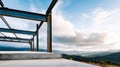 Close-up of steel frame structure under construction with blurred mountainous landscape and cloudy sky in background Royalty Free Stock Photo