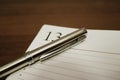Close-up: a steel pen and an open notebook lie on a brown table with a wooden texture. On the page is the number 13 Royalty Free Stock Photo